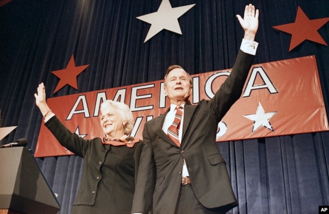 FILE - President-elect George H.W. Bush, right, and his wife Barbara Bush, wave to the crowd at a victory celebration rally, Nov. 8, 1988, Houston, Texas.