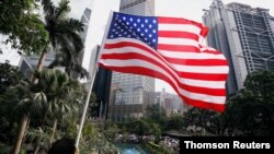 A man holds a U.S. flag as pro-democracy protesters gather at Chater Garden before a march to protest police violence during previous marches, in central Hong Kong, July 28, 2019. 