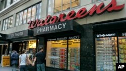 FILE Window shoppers look at a Walgreens storefront in San Francisco, June 26, 2006.