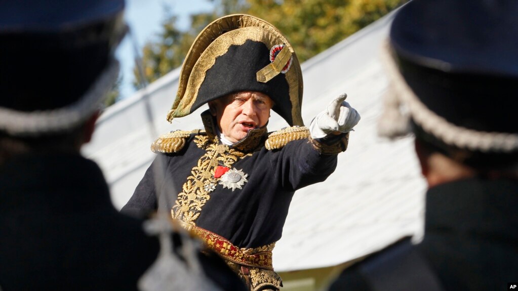 FILE - In this Sunday, Sept. 16, 2012 file photo, Oleg Sokolov, a history professor at St. Petersburg State University, wears a 1812-era French army general's uniforms during a staged battle re-enactment to mark the 200th anniversary of the battle…