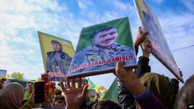 Mourners hold portraits during the funeral of six Kurdish fighters from the Syrian Democratic Forces (SDF) killed in ongoing clashes with Turkish-backed militias in northern Syria, held in Qamishli, northeastern Syria, Dec. 26, 2024.