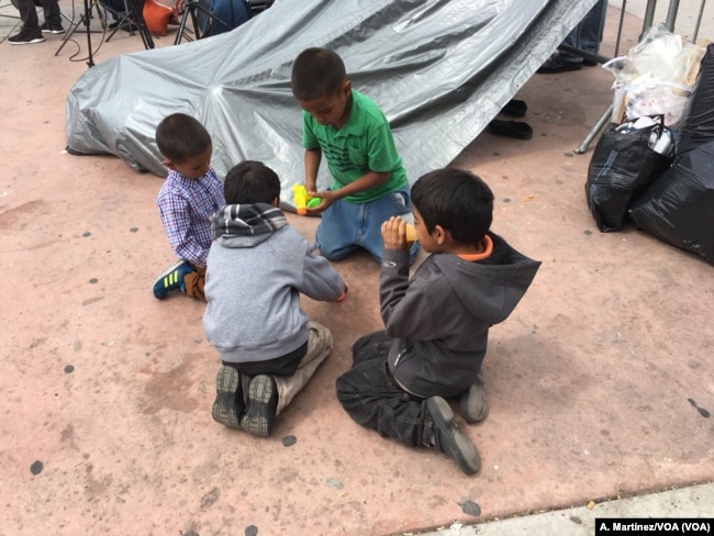 Niños migrantes juegan en una plaza pública del lado mexicano de la frontera con EE.UU. [A. Martínez/VOA].