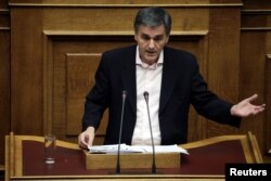 Greek Finance Minister Euclid Tsakalotos delivers a speech during a parliamentary session before a budget vote in Athens, Greece, Dec. 10, 2016.