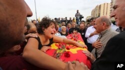 A relative cries over the coffin of Korkmaz Tedik, 25, killed in Saturday's bombing attacks, during his funeral at the Pir Sultan Abdal Cemevi, a place of worship for Turkey’s Alevi community in the outskirts of Ankara, Oct. 11, 2015.