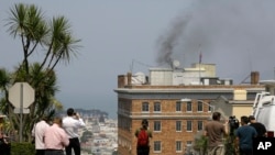 Перехожі дивляться на чорний дим з труби російського консульства в Сан-Франциско перед його закриттям
