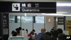 从中国武汉和其他城市飞抵日本成田国际机场的旅客接受体温检测。（2020年1月23日）