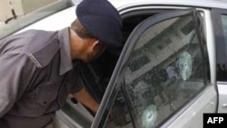 Cảnh sát Pakistan xem xét chiếc xe bị các tay súng tấn công ở Karachi, ngày 28/10/2010