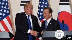 U.S. President Donald Trump, left, and South Korean President Moon Jae-In shake hands during a joint press conference at the presidential Blue House in Seoul, South Korea, Tuesday, Nov. 7, 2017. 