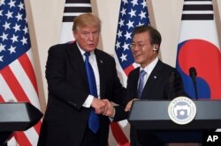 U.S. President Donald Trump, left, and South Korean President Moon Jae-In shake hands during a joint press conference at the presidential Blue House in Seoul, South Korea, Tuesday, Nov. 7, 2017.