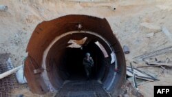 
TOPSHOT - In this picture taken during a media tour organized by the Israeli military on December 15, 2023, an Israeli soldier exits a tunnel that Hamas reportedly used to attack Israel through the Erez border crossing on October 7.