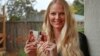 In this Dec. 5, 2018 photo, Diana Sauer holds a family photograph of her father, Warren Deboer, holding her as a baby, and his best friend Russell Anderson, left, in Concord, Calif.