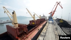 FILE - A cargo ship is loaded with coal during the opening ceremony of a new dock at the North Korean port of Rajin. The dock was jointly built with Russia after last year's completion of a railway link to North Korea.