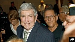 En esta foto de archivo, el activista anticastrista Luis Posada Carriles sonríe al ser recibido por simpatizantes en una cena en Miami el 13 de abril, de 2011.