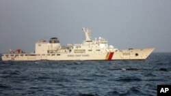 A Chinese trawler (C) capsizes after colliding with a South Korean Coast Guard boat in the waters off Gunsan, south of Seoul December 18, 2010.