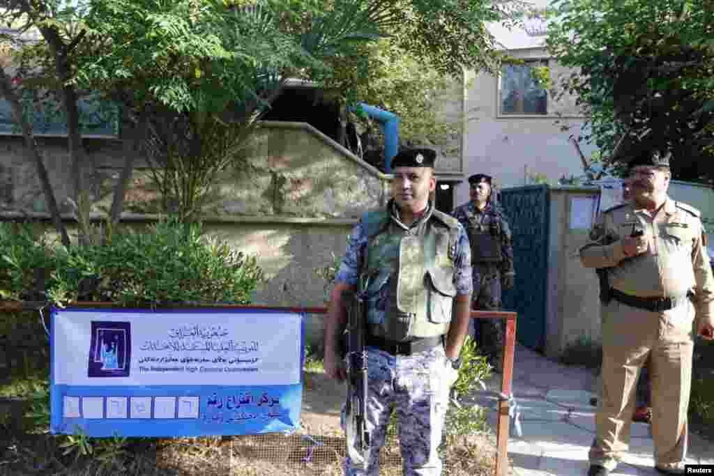 Iraqi policemen stand guard near a polling station during voting for Iraqi parliamentary election in Baghdad April 30, 2014. Iraqis head to the polls on Wednesday in their first national election since U.S. forces withdrew from Iraq in 2011 as Prime Minis