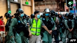 FILE - Police arrest a man during a protest against China's planned national security law in Hong Kong on June 28, 2020. On Aug. 19, 2020, the US formally notified Hong Kong that it has withdrawn from three bilateral deals on extradition and taxation.