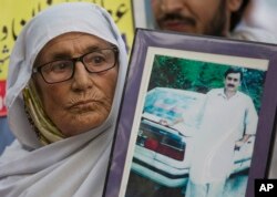 A Pakistani mother holds a picture of her missing son during a rally to observe the International Day of the Disappeared near a Parliament in Islamabad, Pakistan, Aug. 30, 2018.
