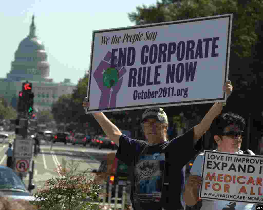 На плакате написано: «Мы, американский народ, говорим: остановите власть корпораций»