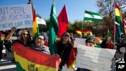 Manifestantes con banderas bolivianas protestan afuera de la Organización de Estados Americanos durante una reunión del consejo Permanente para considerar la situación tras las elecciones de Bolivia, en Washington el miércoles 23 de octubre de 2019.