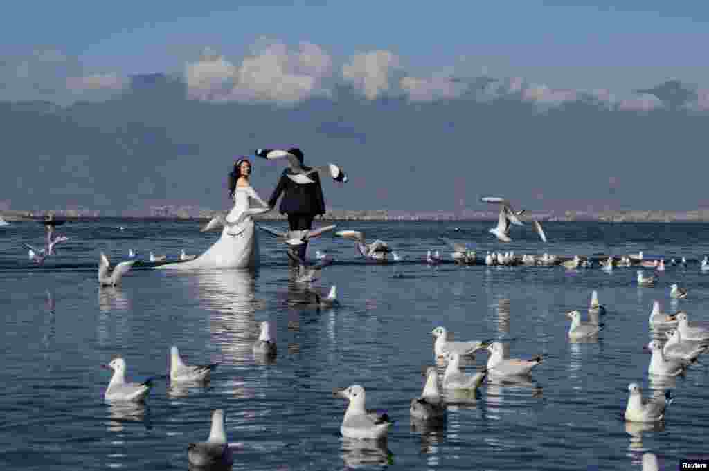 عکس گرفتن یک زوج در روز عروسی شان در دریاچه اِرهايى در استان &quot;یون نان&quot; در چین.