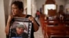 Martha Lorena Alvarado, madre de un manifestante antigubernamental encarcelado, sostiene un cartel con una imagen de su hijo en la Iglesia de San Miguel Arcángel en Masaya. Ella se ha unido a una huelga de hambre para exigir la libertad de sus familiares.