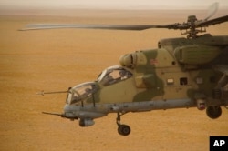 A Russian military helicopter flies over a desert in Deir el-Zour province, Syria, Sept. 15, 2017. A U.S.-backed force in Syria said a Russian airstrike wounded six of its fighters Saturday near Deir el-Zour city, while in southeast Syria, Syrian troops and their Iran-backed allies began a new offensive aiming to capture areas along the Iraq border under the cover of Russian airstrikes.