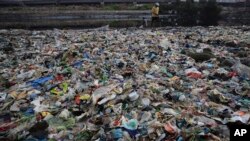 A man walks on the shores the Arabian Sea, littered with plastic and other garbage in Mumbai, India, June 4, 2018. 