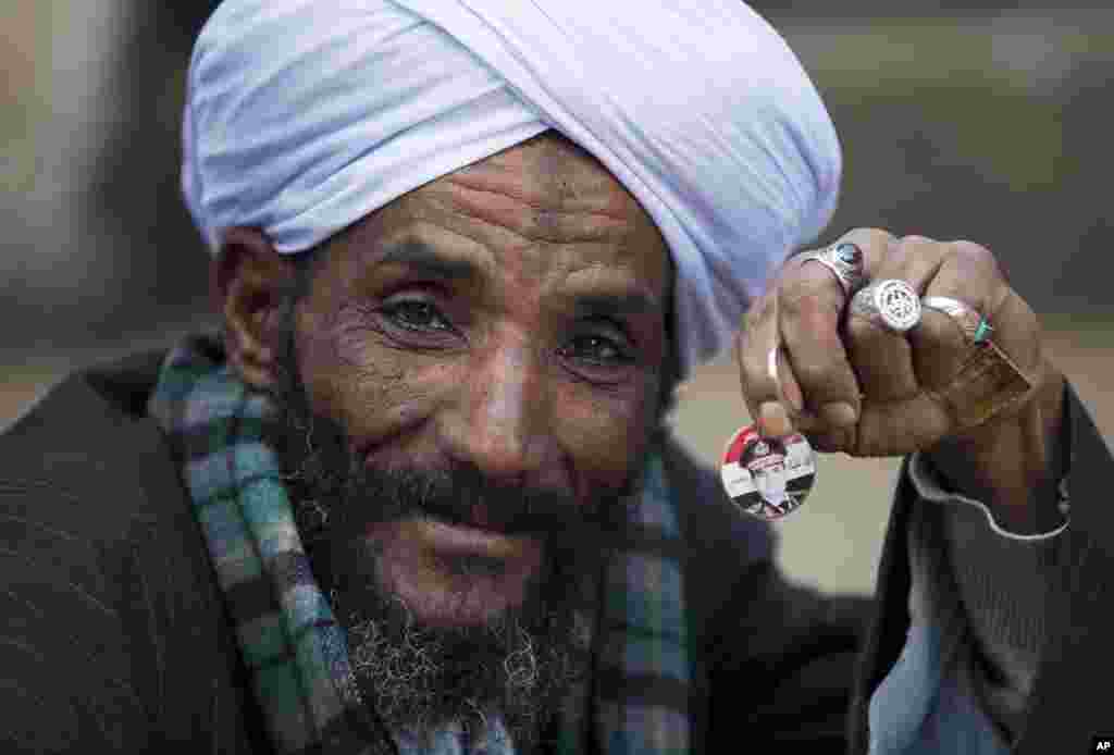 A man holds a pin with a picture of Egypt&#39;s Defense Minister Gen. Abdel-Fattah el-Sissi as he waits for his turn to cast his vote in the country&#39;s constitutional referendum in Cairo.