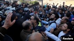 FILE - Christians clash with riot police in front of Cairo’s Coptic Cathedral after an explosion inside the cathedral in Cairo, Egypt, Dec. 11, 2016. 