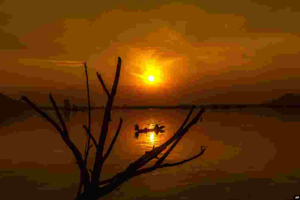 Kashmiri fishermen row their Shikara, or traditional wooden boat, on their way home during sunset at the Dal Lake, in Srinagar, Indian controlled Kashmir.