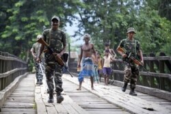 Indian security personnel patrol on a road ahead of the publication of the final draft of the National Register of Citizens (NRC), at Kachari Para village, in Hojai district, northeastern state of Assam, India, Aug. 30, 2019.