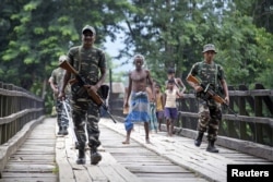 Indian security personnel patrol on a road ahead of the publication of the final draft of the National Register of Citizens (NRC), at Kachari Para village, in Hojai district, northeastern state of Assam, India, Aug. 30, 2019.