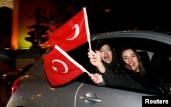 FILE - People of the Turkish community living in Germany, supporting Turkish President Tayyip Erdogan, celebrate on Kurfuerstendamm boulevard after news bulletins on the outcome of Turkey's referendum on the constitution, in Berlin, April 16, 2017.
