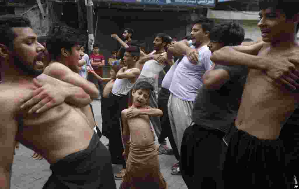 A Shi&#39;ite Muslim boy beats his chest with others during a Muharram procession, in Lahore, Pakistan.