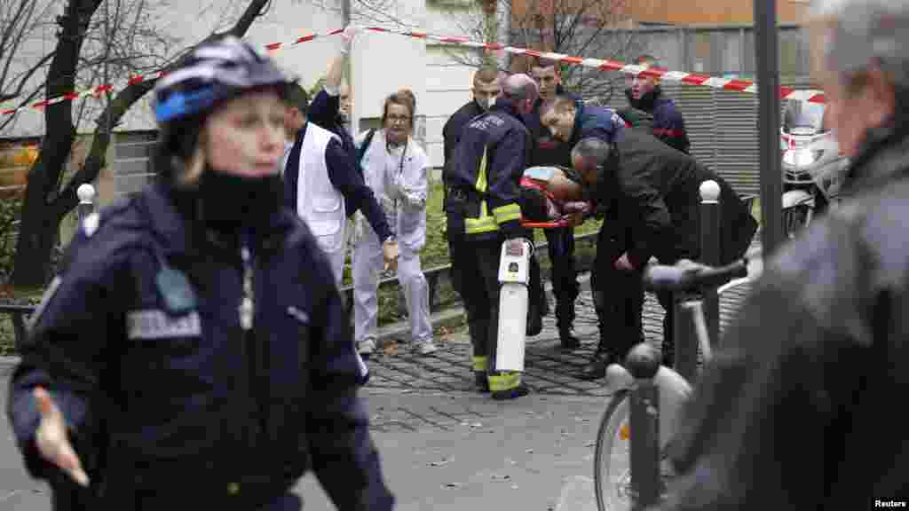 Les pompiers transportent une victime sur une civière après une fusillade dans les bureaux parisiens de Charlie Hebdo, un hebdomadaire satirique, le 7 janvier 2015.