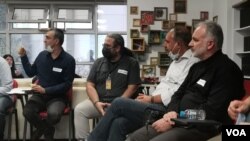 Ayhan Bîlgen di civînekê de xuya dibe