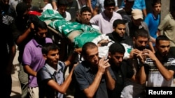 FILE - A new poll shows strong Palestinian support for Hamas' strategy of armed struggle against Israel. Palestinians carry the body of a Hamas militant killed in an Israeli airstrike in Gaza City in August.