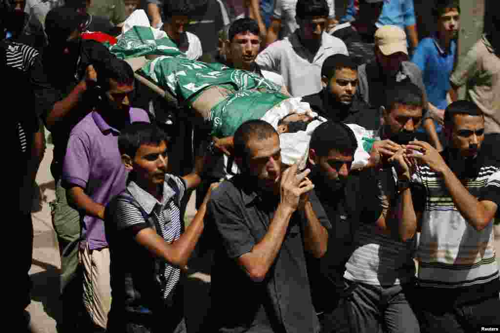 Palestinians carry the body of a Hamas militant, who was killed by an Israeli air strike, during his funeral in Gaza City, Aug. 26, 2014.