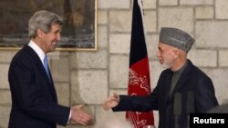 Ngoại trưởng Kerry (trái) bắt tay với Tổng thống Afghanistan Hamid Karzai vào cuối buổi họp báo chung tại dinh tổng thống ở Kabul, 25/3/2013.