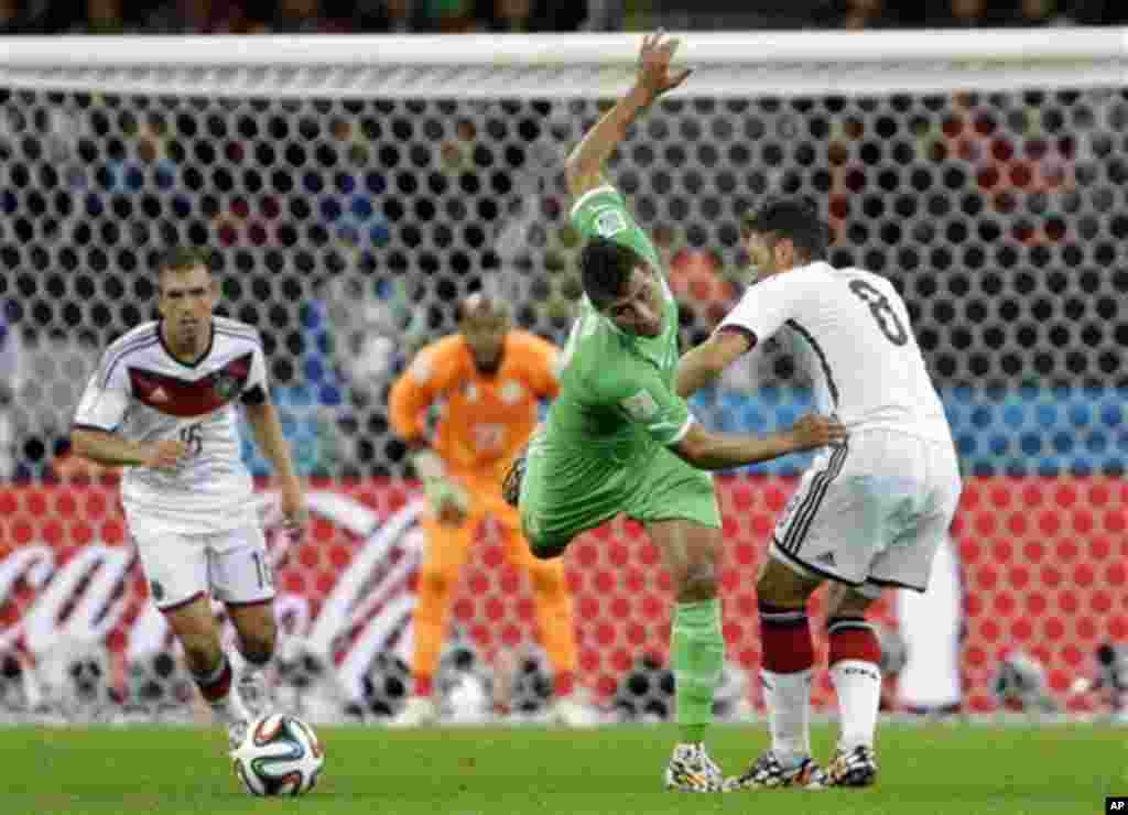 Algeria's Saphir Taider, left, is challenged by Germany's Mesut Ozil (8) during the World Cup round of 16 soccer match between Germany and Algeria at the Estadio Beira-Rio in Porto Alegre, Brazil, Monday, June 30, 2014. (AP Photo/Sergei Grits)