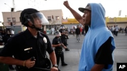 A protester confronts a Los Angles police officer during a demonstration in reaction to the acquittal of neighborhood watch volunteer George Zimmerman on July 15, 2013, in Los Angeles.