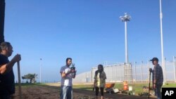 Daniel Watman, second from left, who oversees a cross-border garden in San Diego, Calif., and Tijuana, Mexico, speaks with volunteers during a replanting operation in Friendship Park, within California's Border Field State Park, Jan. 25, 2020. 