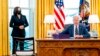 President Joe Biden, accompanied by Vice President Kamala Harris, looks up after signing the American Rescue Plan, a coronavirus relief package, in the Oval Office of the White House, March 11, 2021, in Washington.