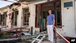 FILE - A physician stands in front of a therapy department which was destroyed in a Russian attack on a hospital in Zolochiv, Kharkiv region, Ukraine, July 31, 2022.