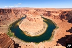 FILE - The Colorado River flows at Horseshoe Bend in the Glen Canyon National Recreation Area, in Page, Arizona, June 8, 2022.