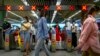 FILE - Commuters walk through a subway station during the morning rush hour in the central business district in Beijing, Aug. 9, 2022.