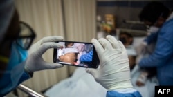 Foto ilustrasi yang menunjukkan seorang dokter di Rumah Sakit Arzobispo Loayza di Lima, Peru, tengah memeriksa pasiennya pada 16 Agustus 2022. (Foto: AFP/Ernesto Benavides)