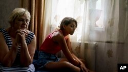 Russia Ukraine War Youth Anastasiia Aleksandrova, 12, right, sits with her grandmother, Olena, at their home in Sloviansk, Donetsk region, eastern Ukraine, Aug. 8, 2022.