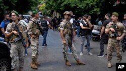 Lebanese soldiers stand guard outside a bank where an armed man has taken hostages, in Beirut, Lebanon, Aug. 11, 2022. 