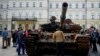 In this file image, a man looks at a destroyed Russian tank placed as a symbol of war in downtown Kyiv, Ukraine, May 23, 2022. (AP Photo/Natacha Pisarenko, File)